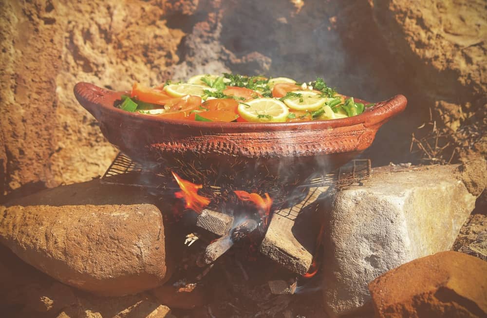 Ceramic dish with vegetables on fire